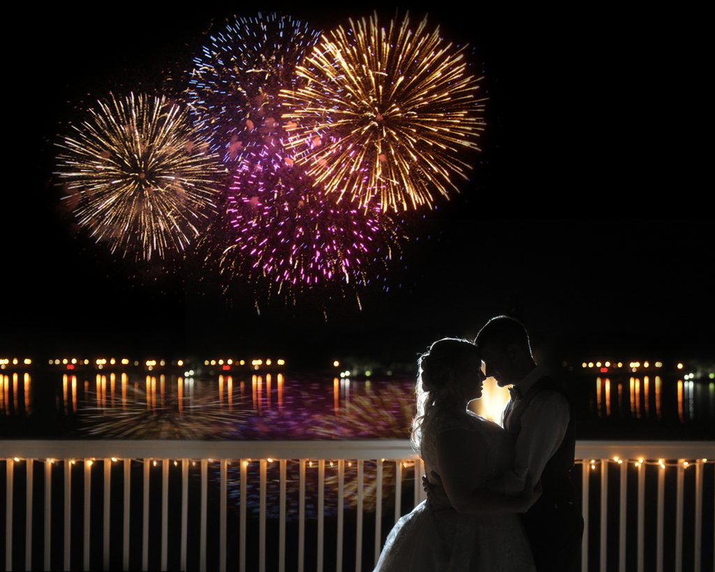 Jennifer Juniper Photography - Bride and groom kissing with fireworks in background