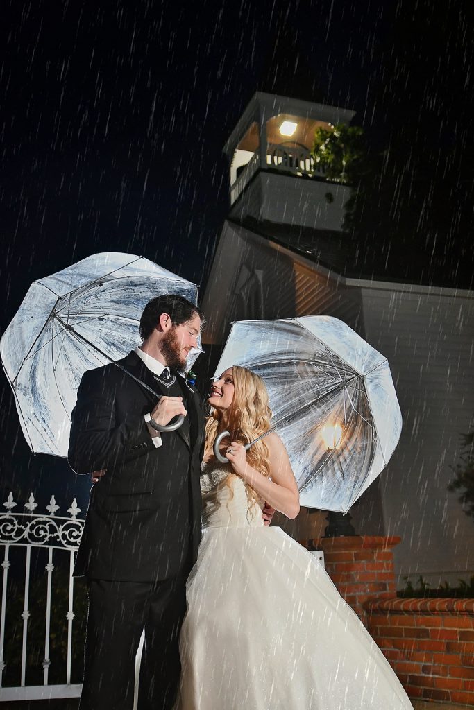 Jennifer Juniper Photography - Bride and groom holding umbrellas in the rain