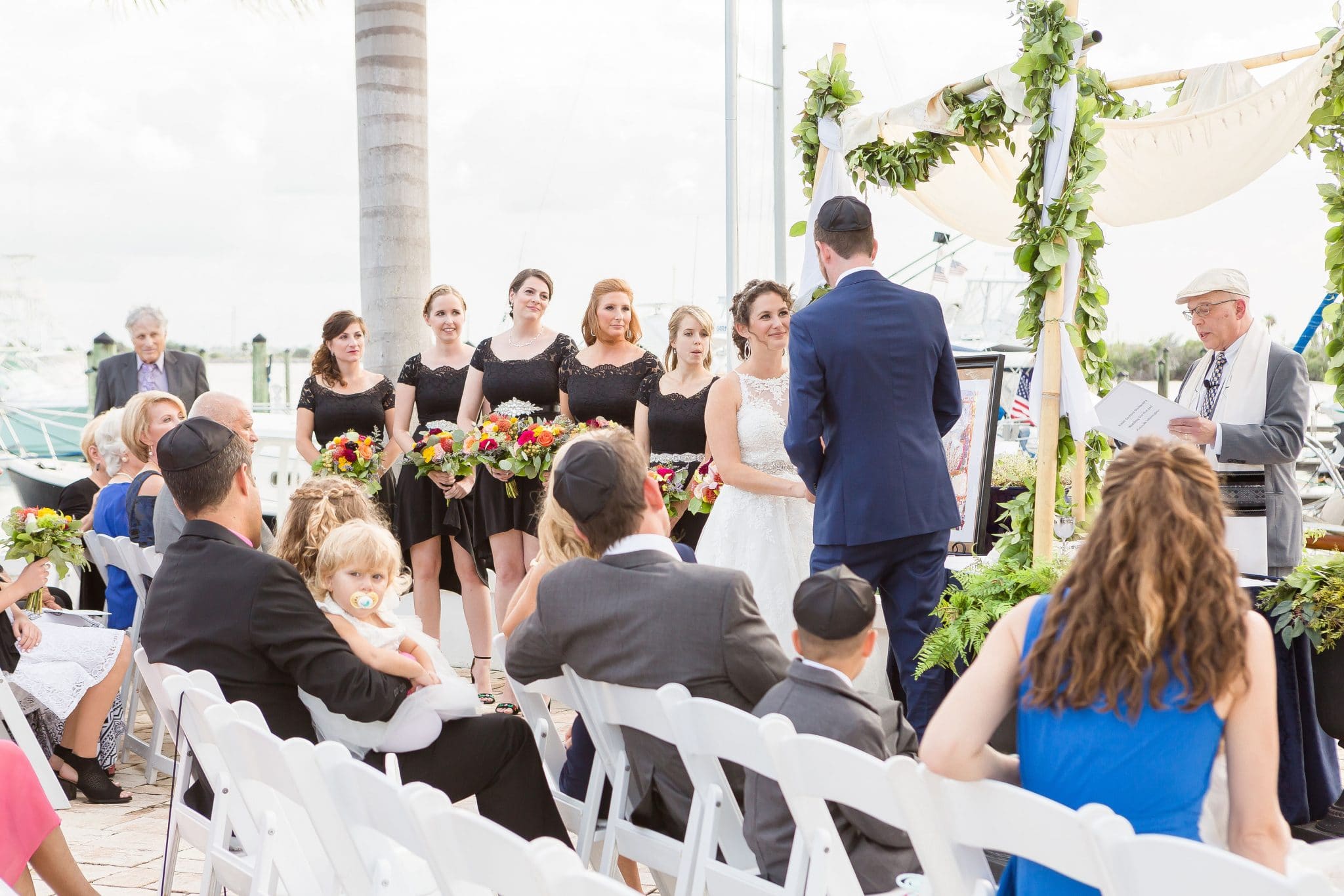 bride with bridesmaids and groom at ceremony with rabbi