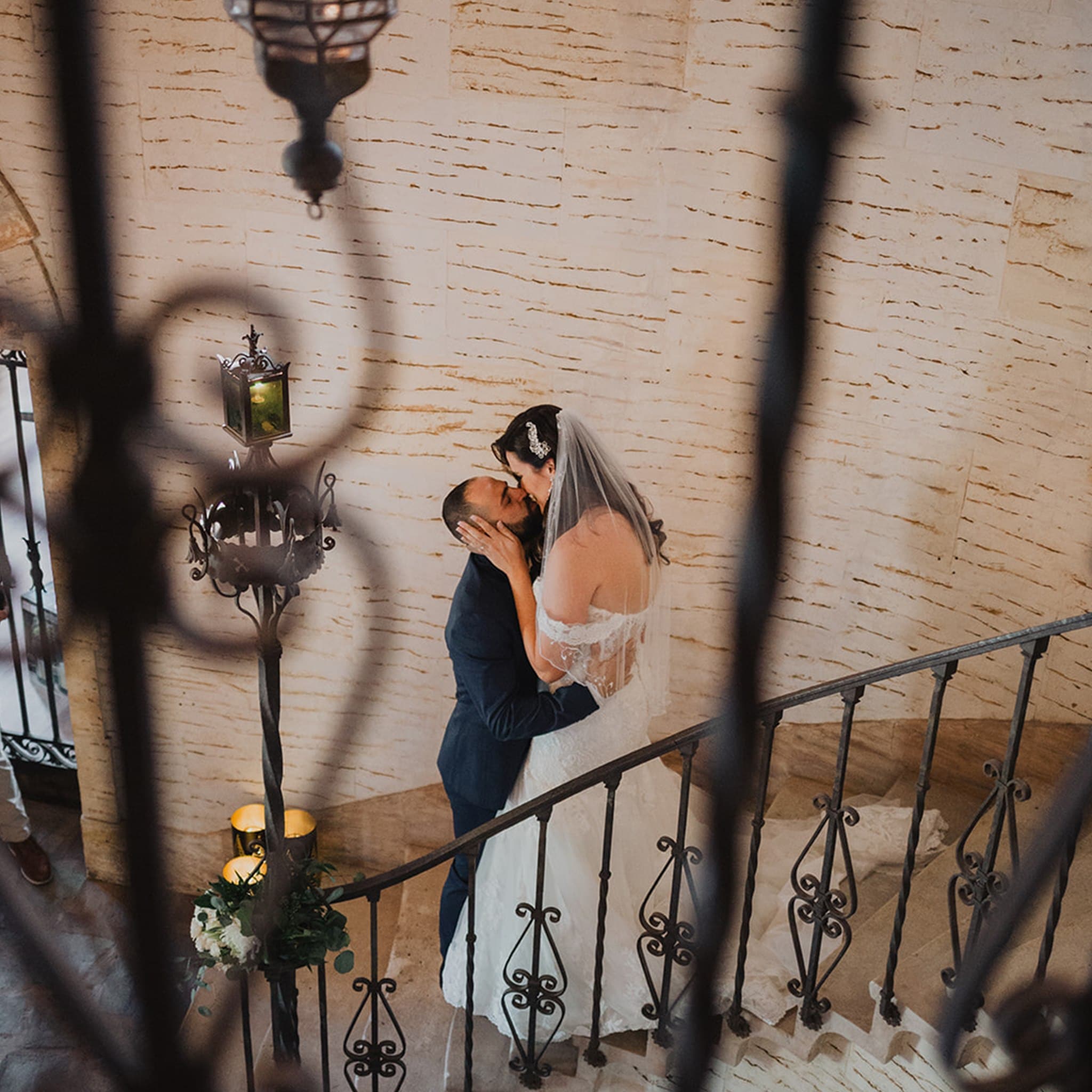 bride and groom kissing on the staircase of the Howey Mansion