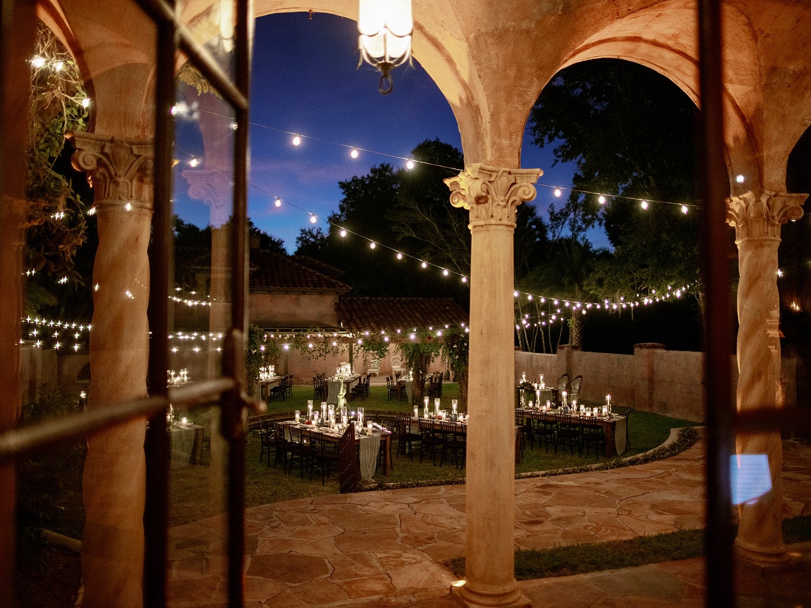 strings of lights over tables in open courtyard outside
