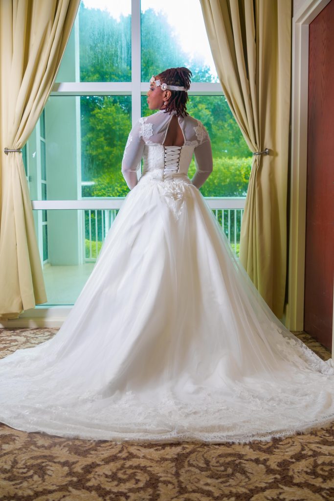 Unique Elements - Bride in dress in front of window