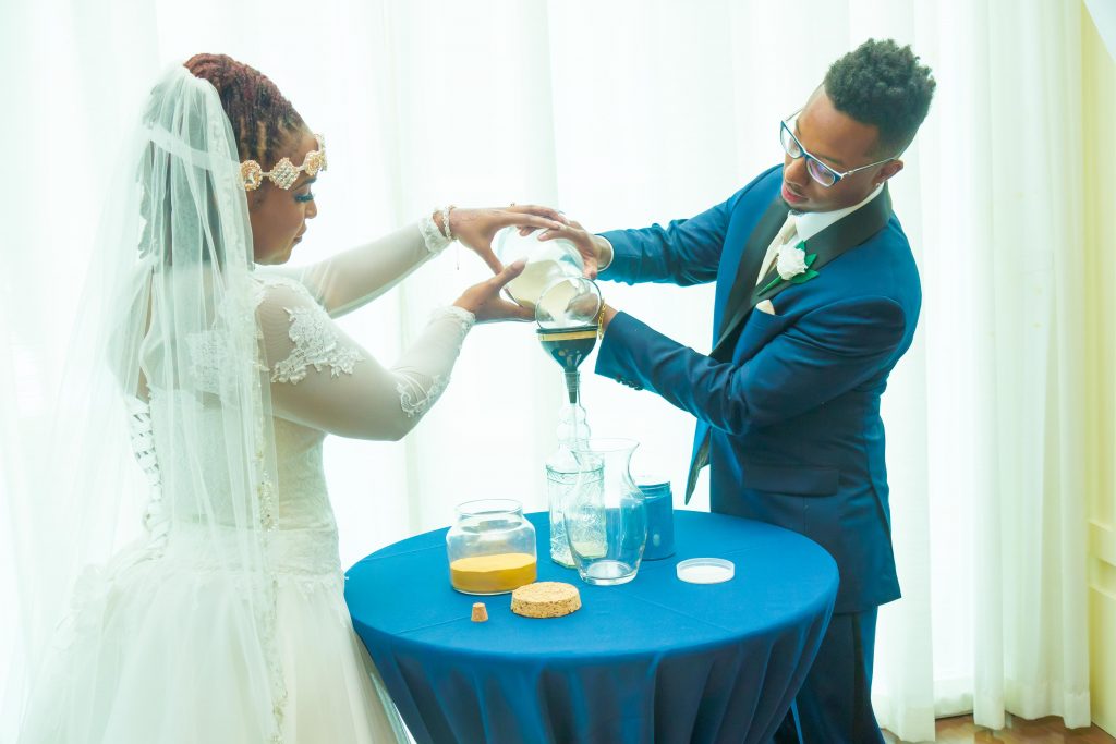 Unique Elements - Bride and groom pouring sand into jar together
