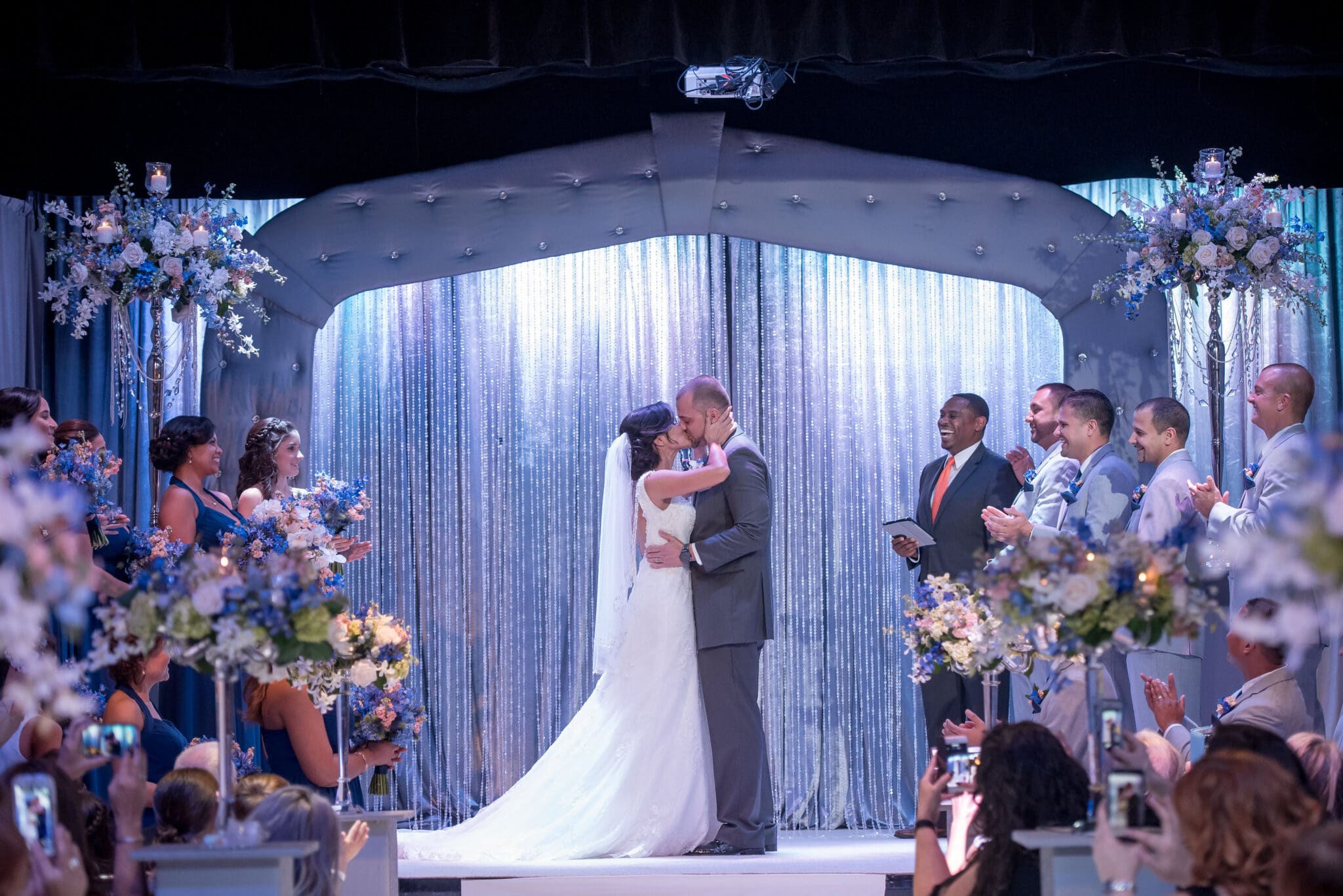 Anna Christine Events, bride & groom kissing in front of curtain at ceremony