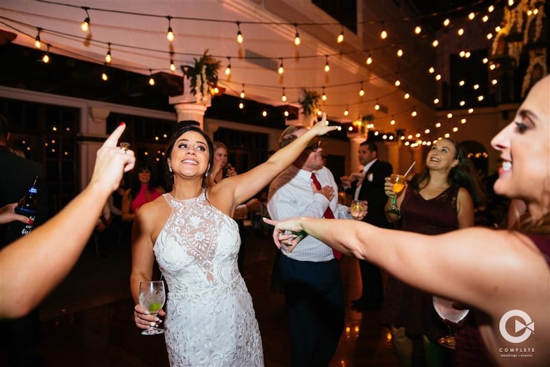 Complete Weddings + Events bride dancing outside with guests under market lights