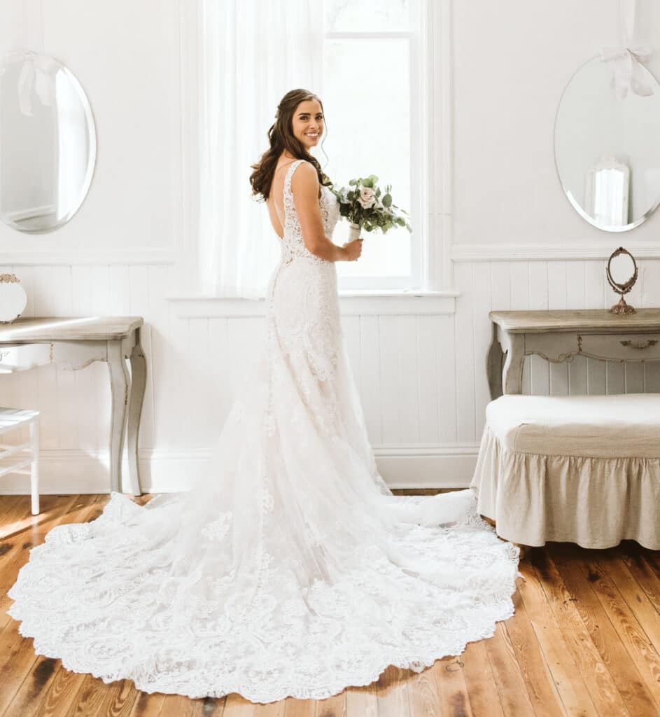 bride standing in front of window with bouquet