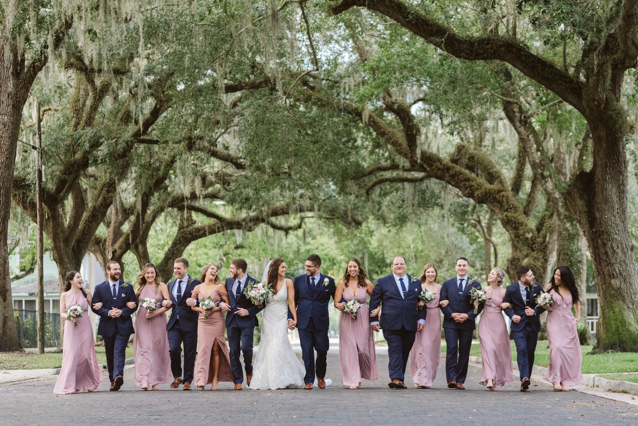 bridal party walking under trees