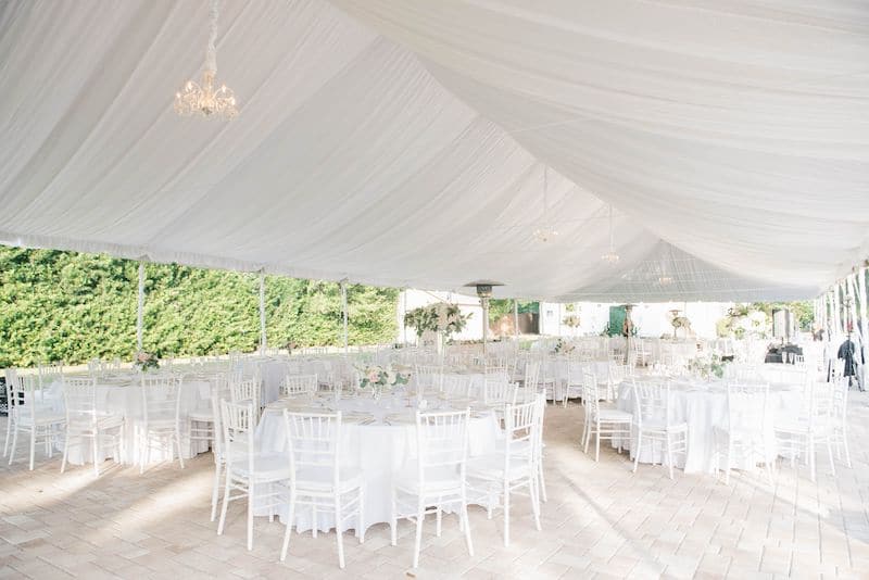 Just Marry outdoor wedding reception set up underneath white tent