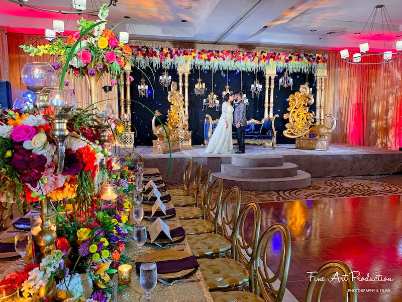 Just Marry beautiful wedding reception with colorful flowers and bride and groom standing on stage