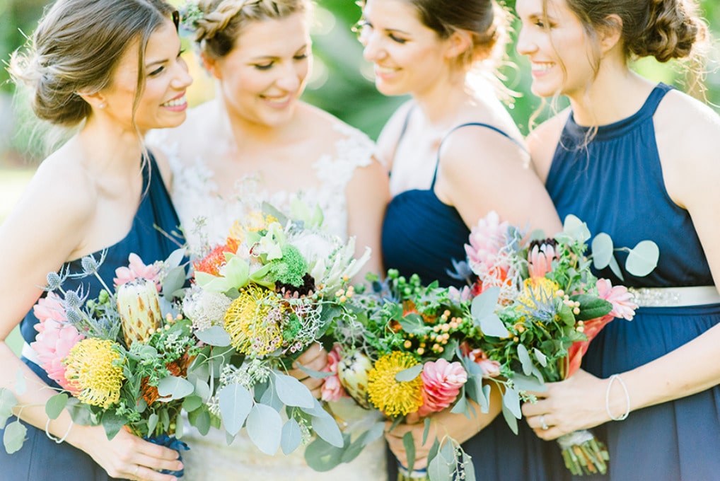 bride with bridesmaids holding flowers
