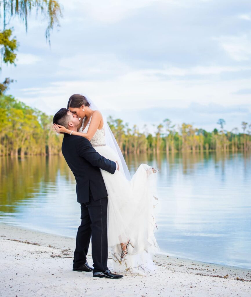 bride & groom kissing by water