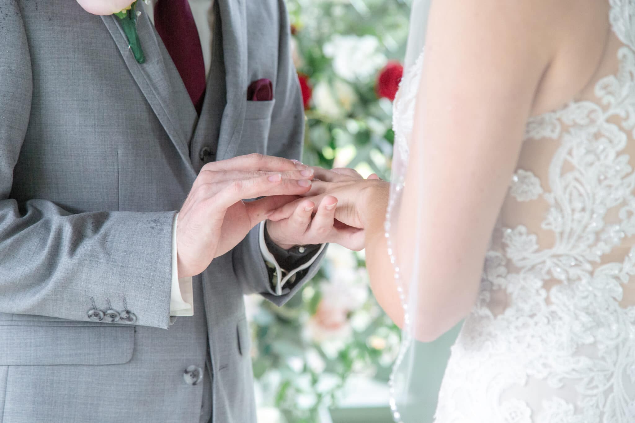 groom placing the wedding band on brides hand at wedding ceremony