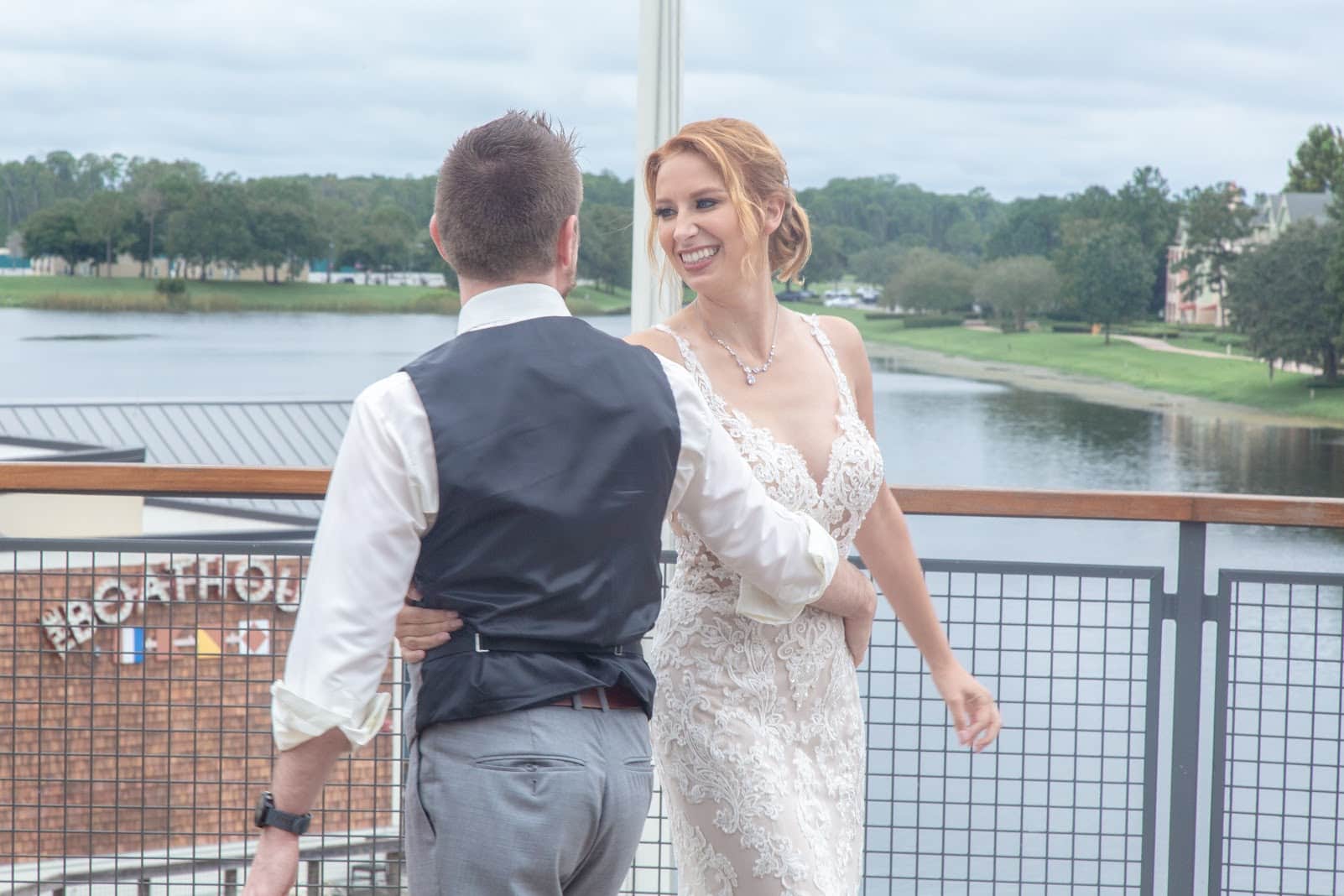 bride and groom dancing on patio of paddlefish overlooking water during wedding reception