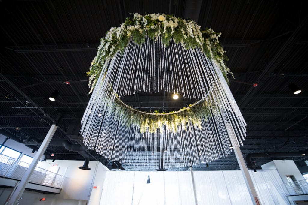 looking up at round modern chandelier with flowers and hanging crystals