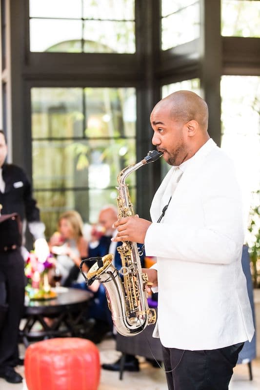 saxophone player performing at a wedding during cocktail hour