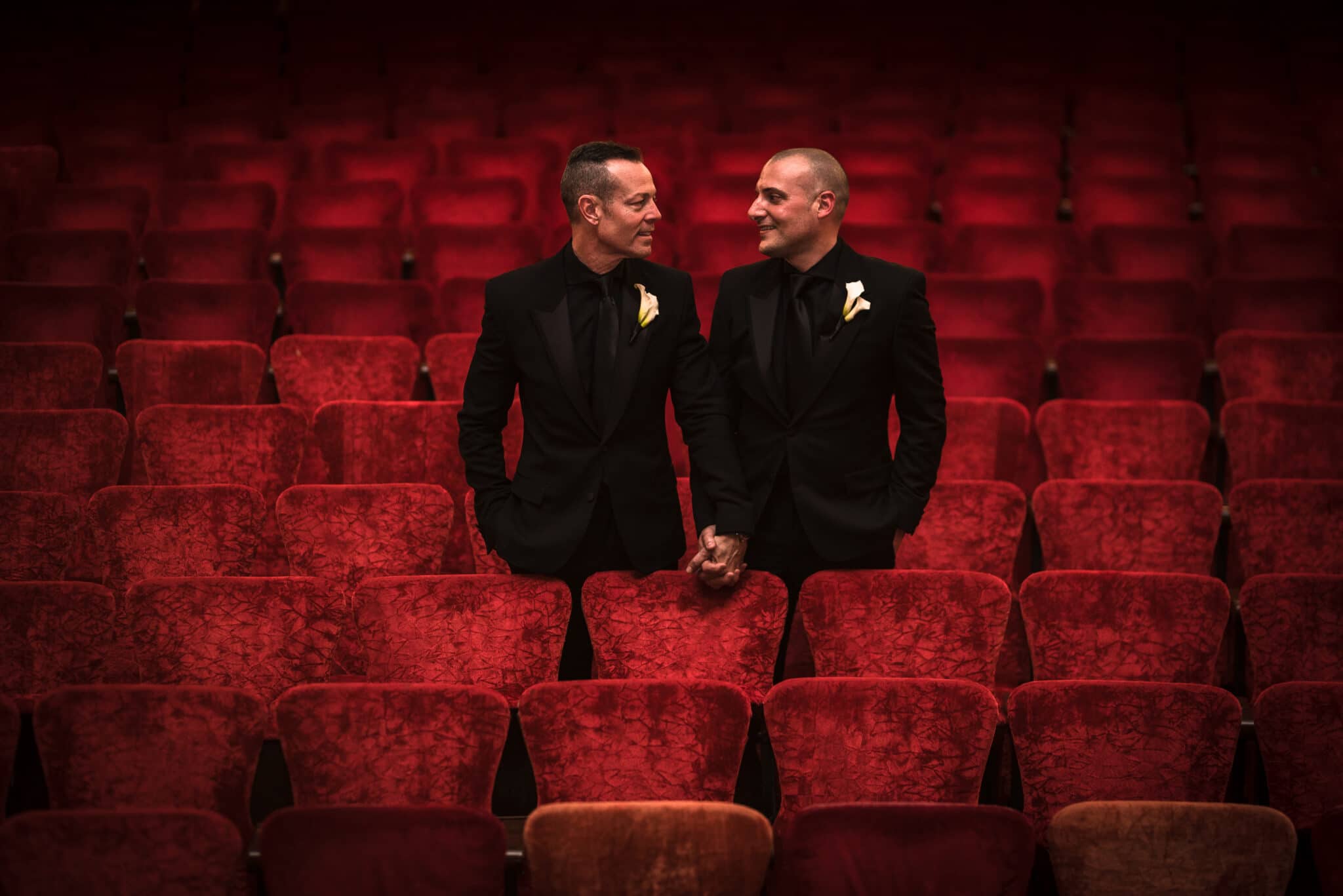 grooms standing in theatre seats