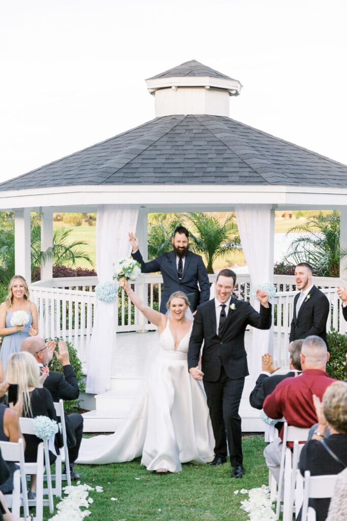 bride and groom celebrating after getting married in front of a gazebo