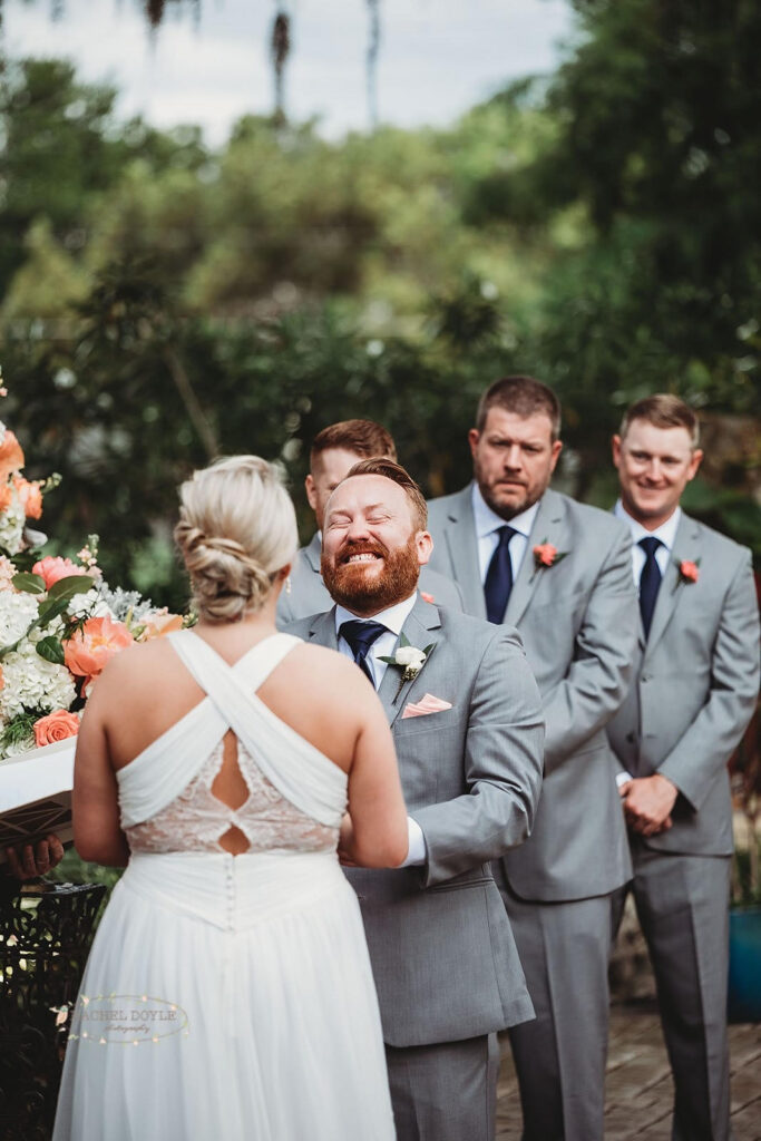 groom laughing enthusiastically during wedding ceremony while his groomsmen look on