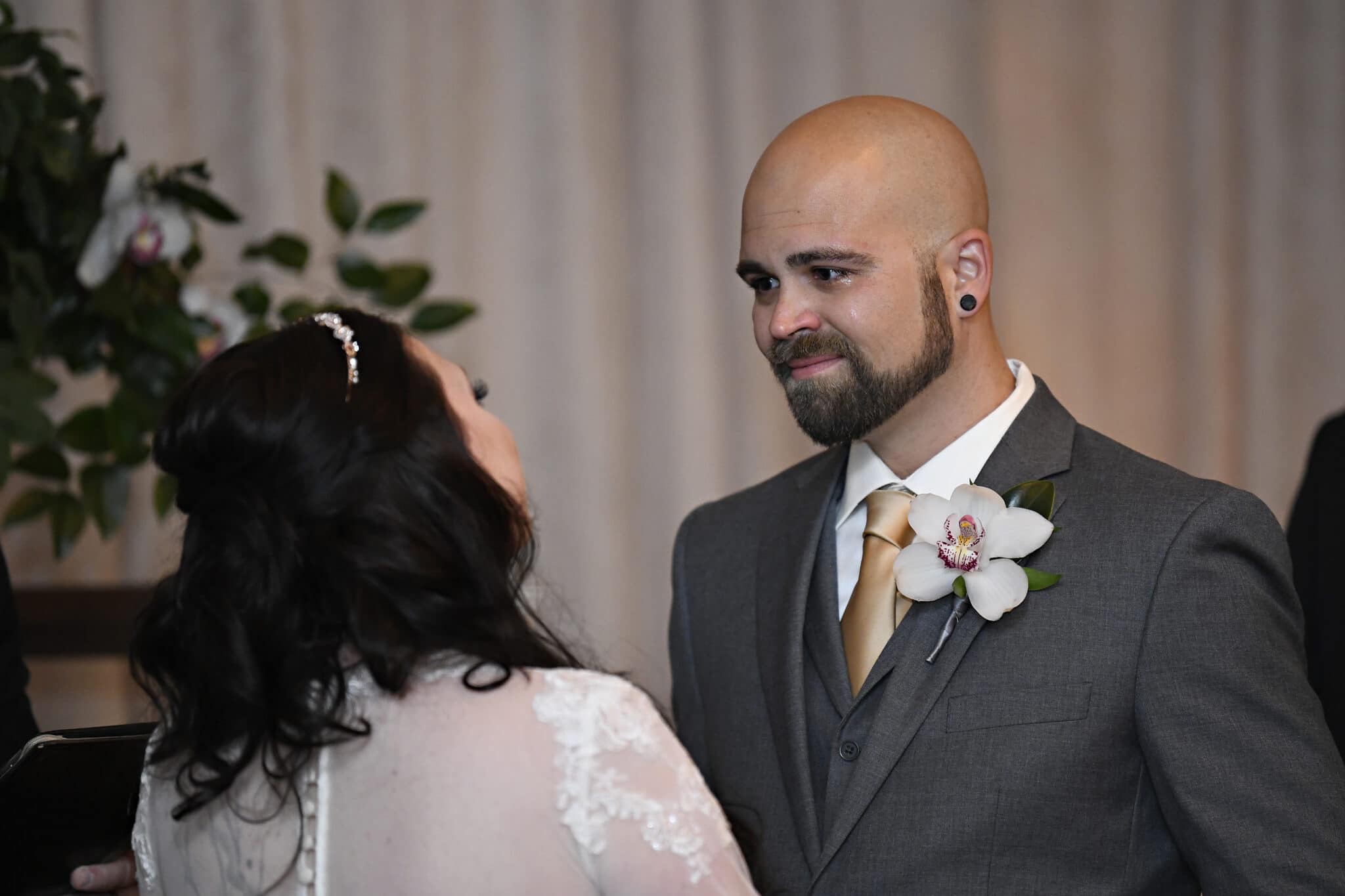 groom looking into bride's eyes crying while saying wedding vows