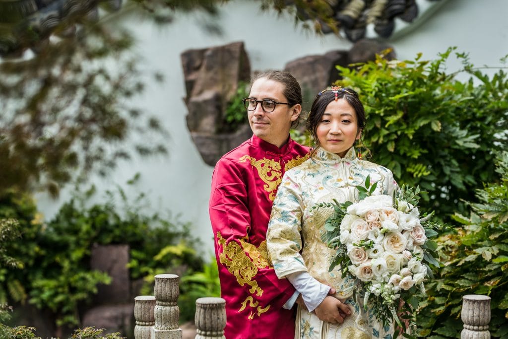 groom in red and chinese bride in traditional asian wedding dress