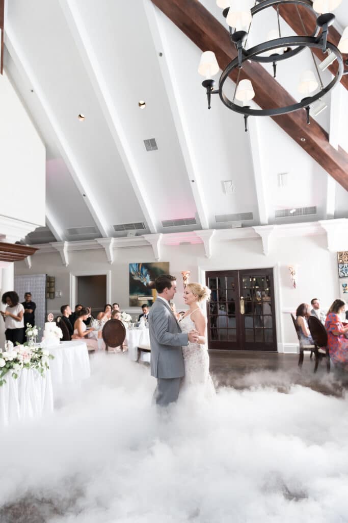 bride and groom having their first dance, with dance floor covered in fog