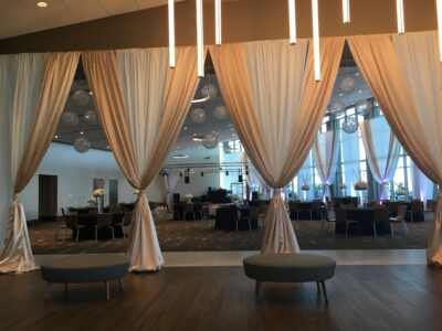 indoor ballroom with wood floors, large curtains, and modern lighting