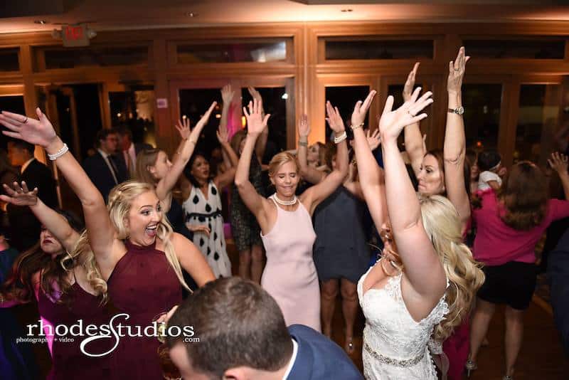 woman dancing with their arms up while on dance floor with their bride