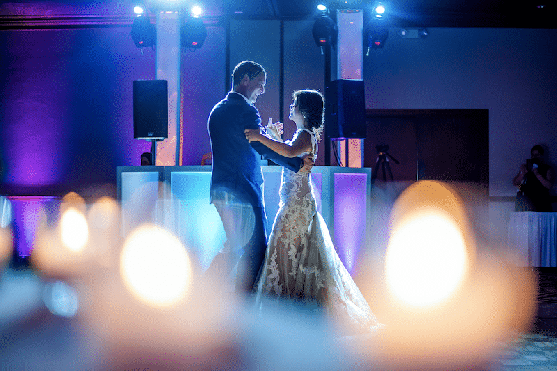 bride and groom enjoying a private dance at their wedding reception with DJ booth behind them