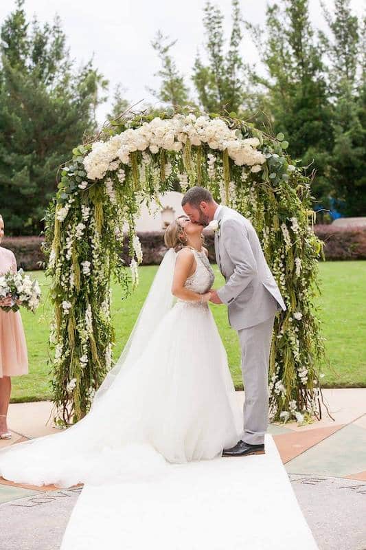 bride and groom kissing after getting married while still standing in front of altar