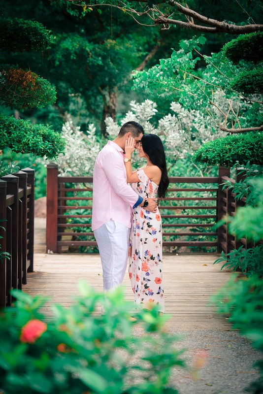 couple standing on wooden walkway through beautiful garden photo by Cona Studios