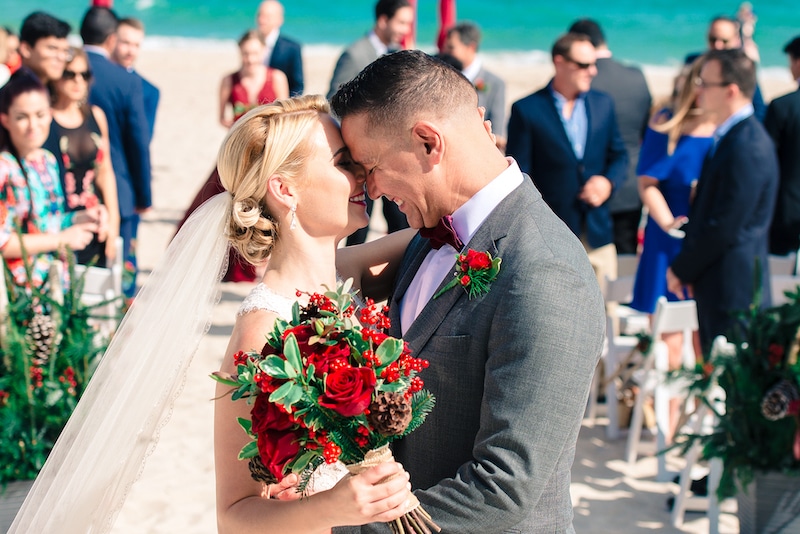 bride and groom embracing after getting married on the beach photo by Cona Studios