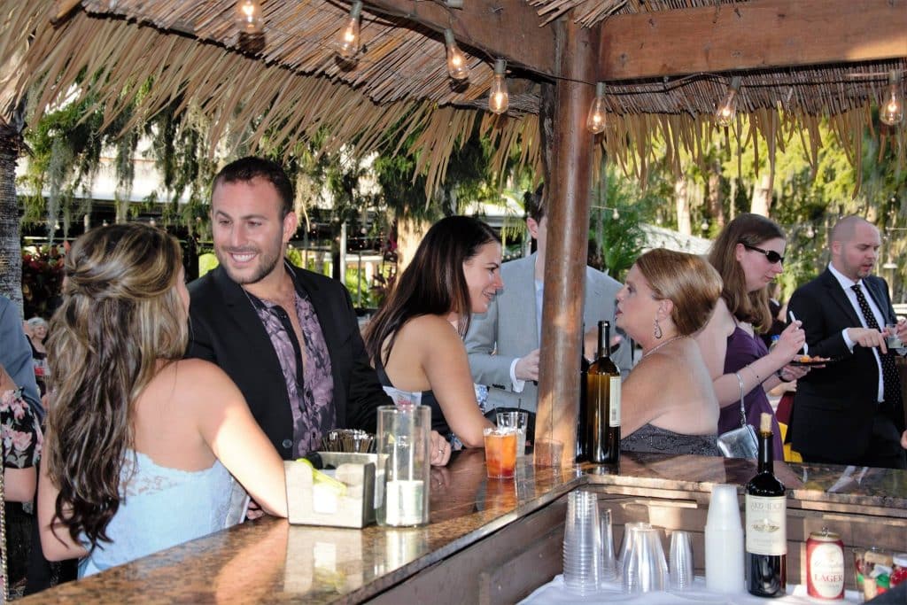 guests mingling and getting drinks at outdoor tiki bar during cocktail hour
