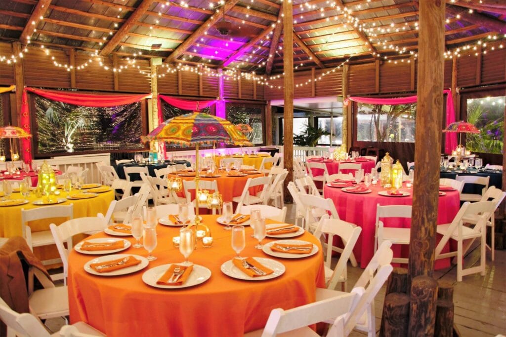 room decorated with bright colors like orange, pink, and yellow for wedding reception