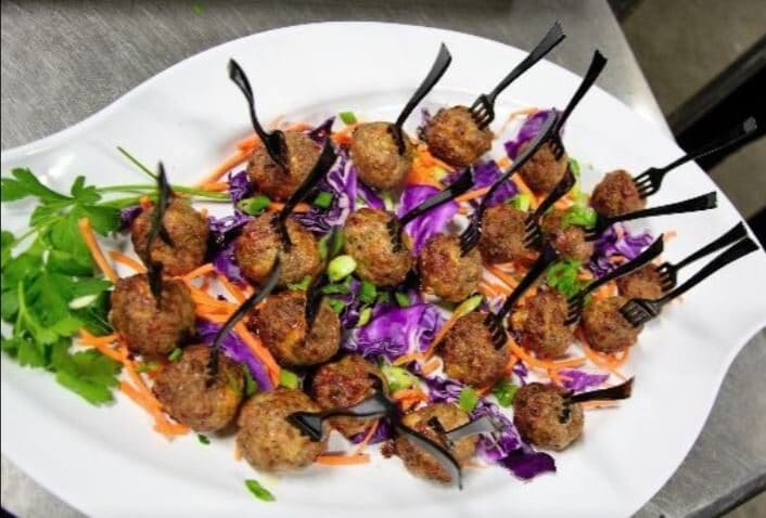 individual meatballs on a plate for cocktail hour at a wedding reception