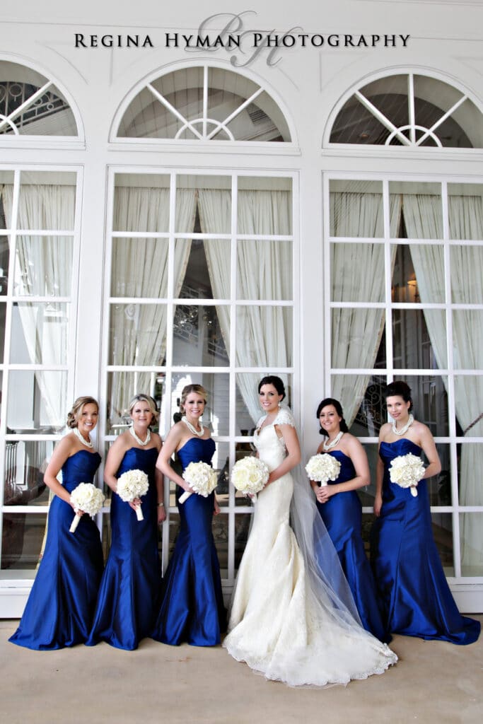 bride with bridesmaids in blue in front of window