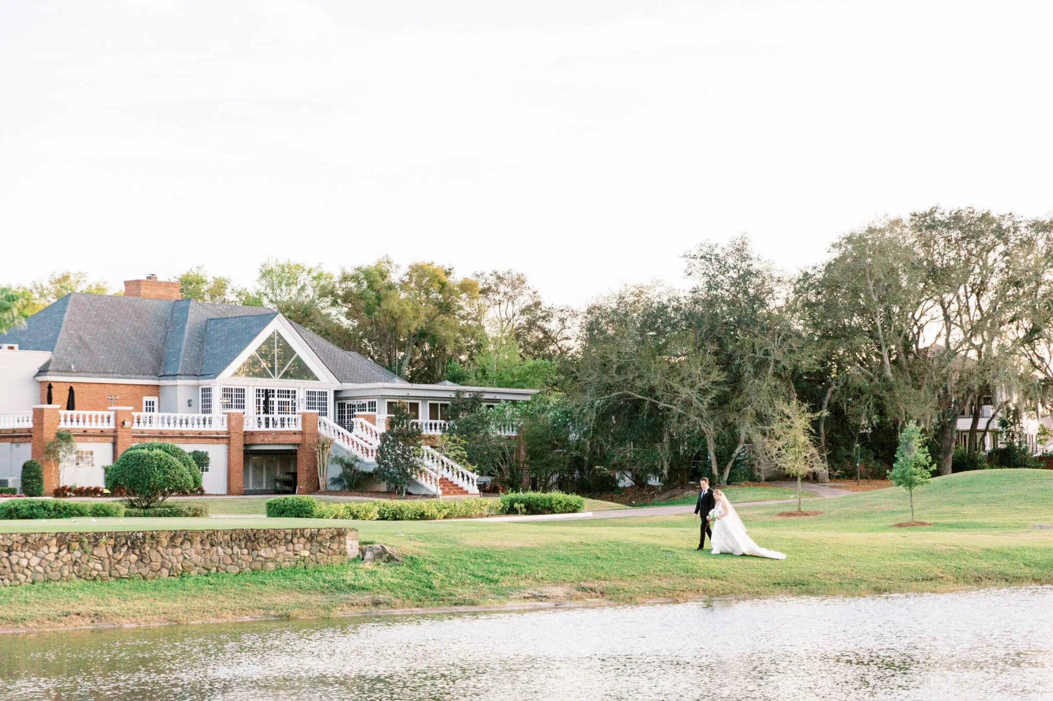 bride and groom walking next to lake outside of Heathrow Country Club
