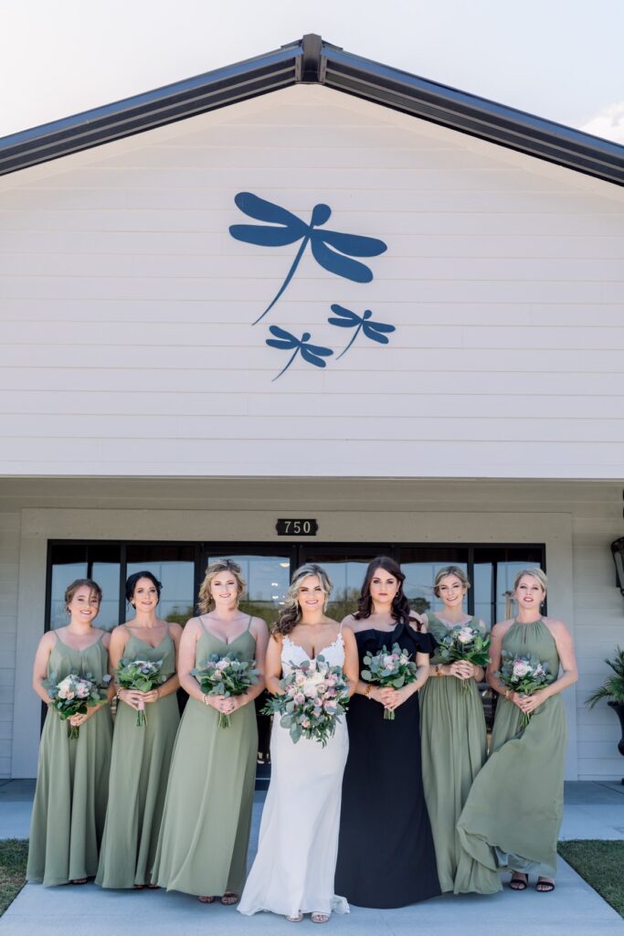 bridal party standing under painted dragonflys