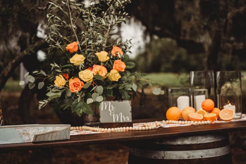 table for decorations at wedding made from dark wood and two wood barrels