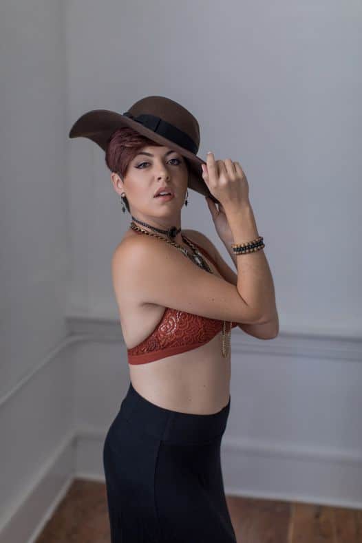 woman in a large brown hat with hair and make-up by the Karmel Design Team