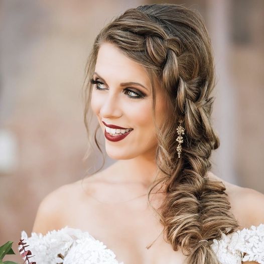 bride smiling with her hair with hair and make-up by the Karmel Design Team resting over her shoulder