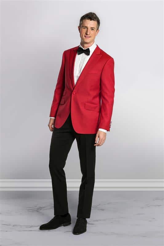 man in a red tux jacket, black dress pants, black shoes, and black bow tie