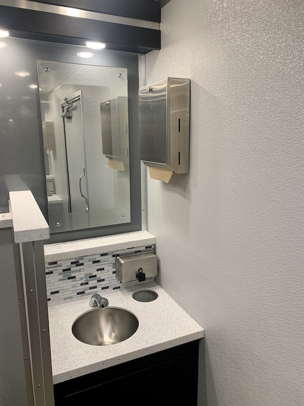 sink and mirror inside of restrooms rented from Luxe Flush