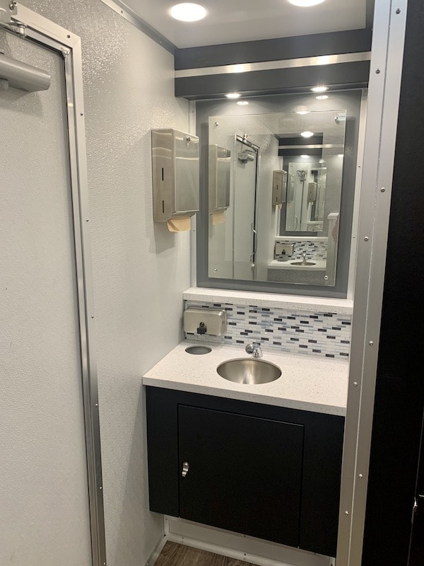 sink and mirror located inside of rented restrooms from Luxe Flush