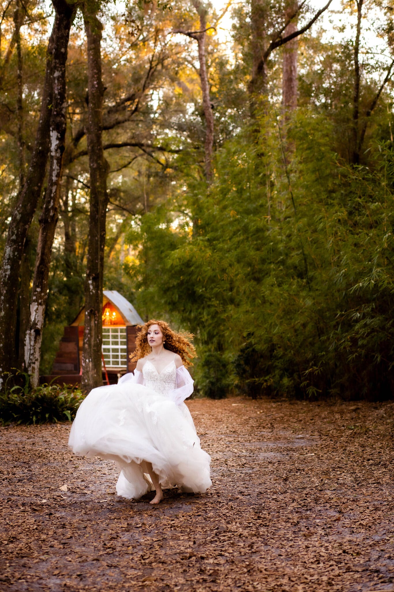 bride runs in wedding gown outside of rustic wedding venue in woodsy area