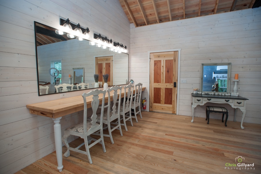 white room with large mirror, table, and chairs for getting ready