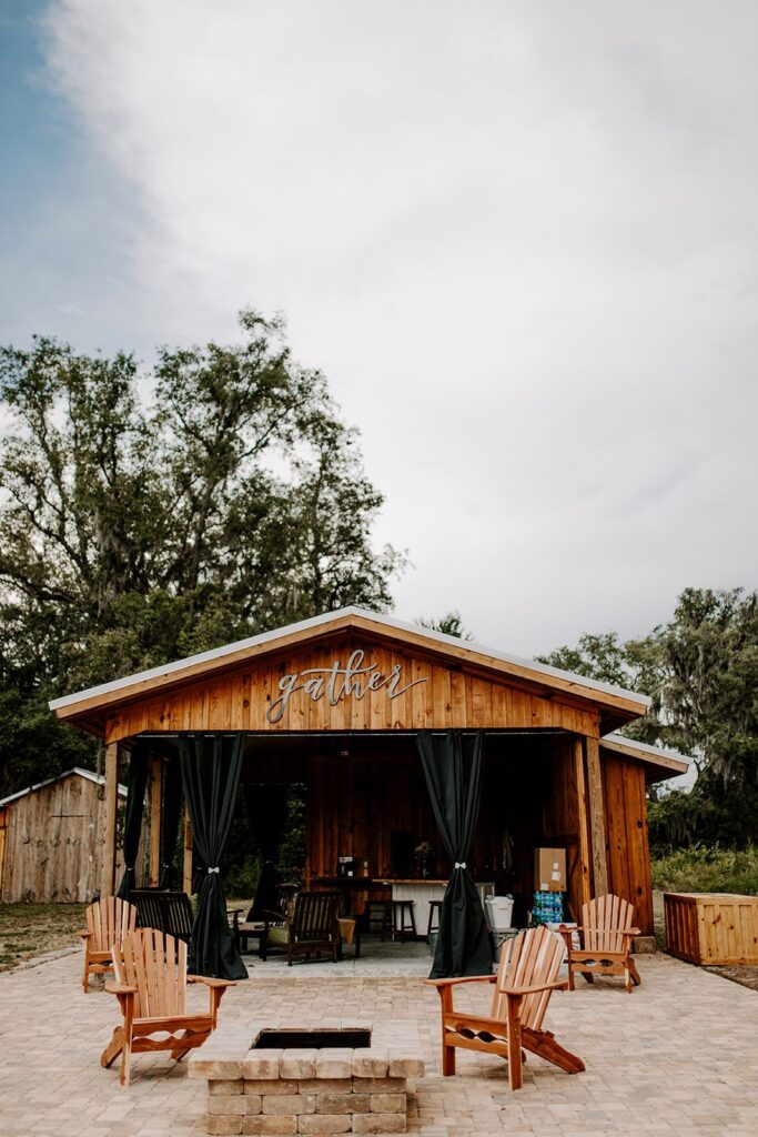 summer kitchen with fire pit, chairs, and full kitchen for entertaining at legacy at oak meadows florida wedding venue