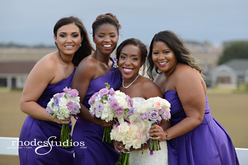 bride and her bridesmaids holding their flower bouquets which match their dresses
