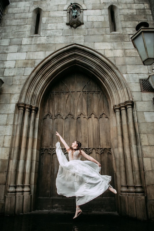 bride dancing in front of an old wooden door of a stone building