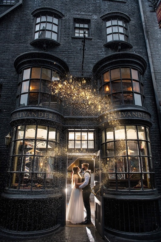 bride and groom standing in the doorway of Olivanders with magic dust twirling around them