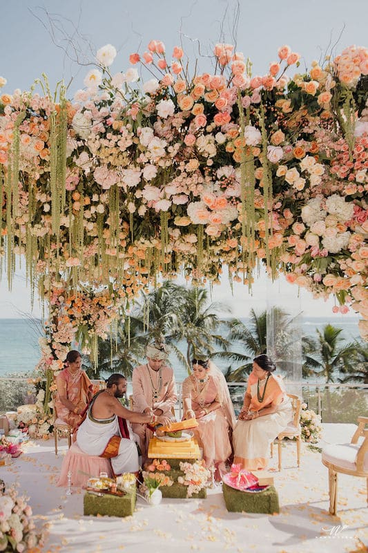 outdoor wedding ceremony overlooking the ocean with the entire area decorated in beautiful flowers